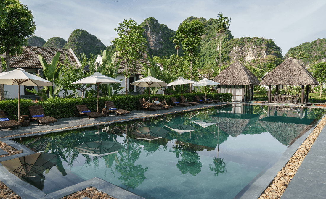The infinity pool at Aravinda Resort, set against a backdrop of rice fields and surrounding greenery