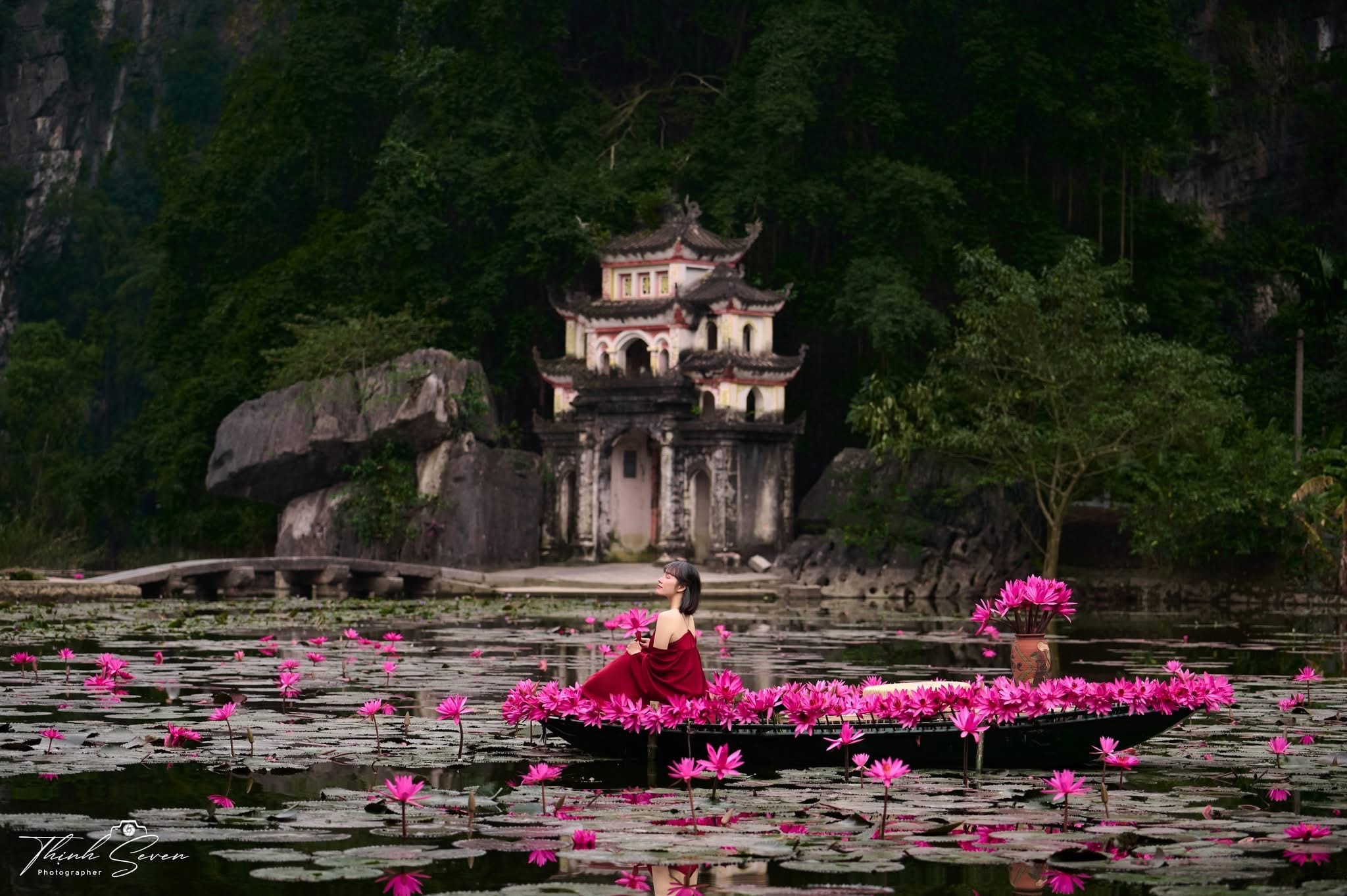 The tranquil lake at Bich Dong Pagoda reflects the mountains during the seasonal water lily bloom, capturing a unique aspect of Ninh Binh's spring.