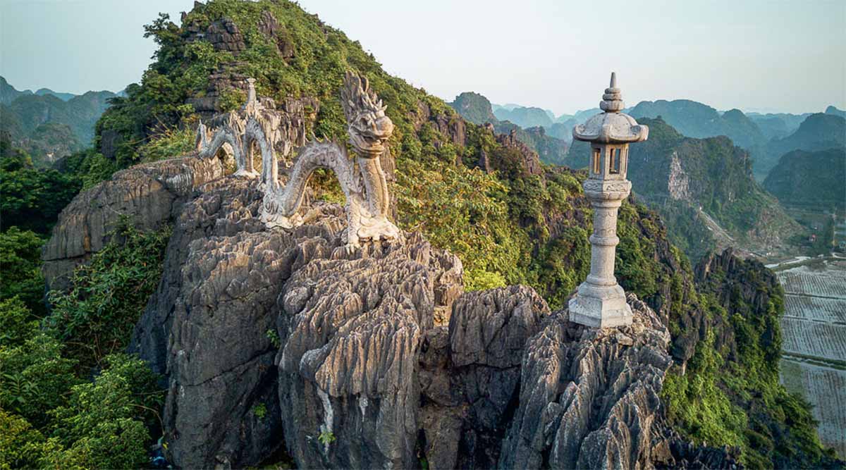 An intricate close-up of the carved stone dragon statue coiling along the summit.