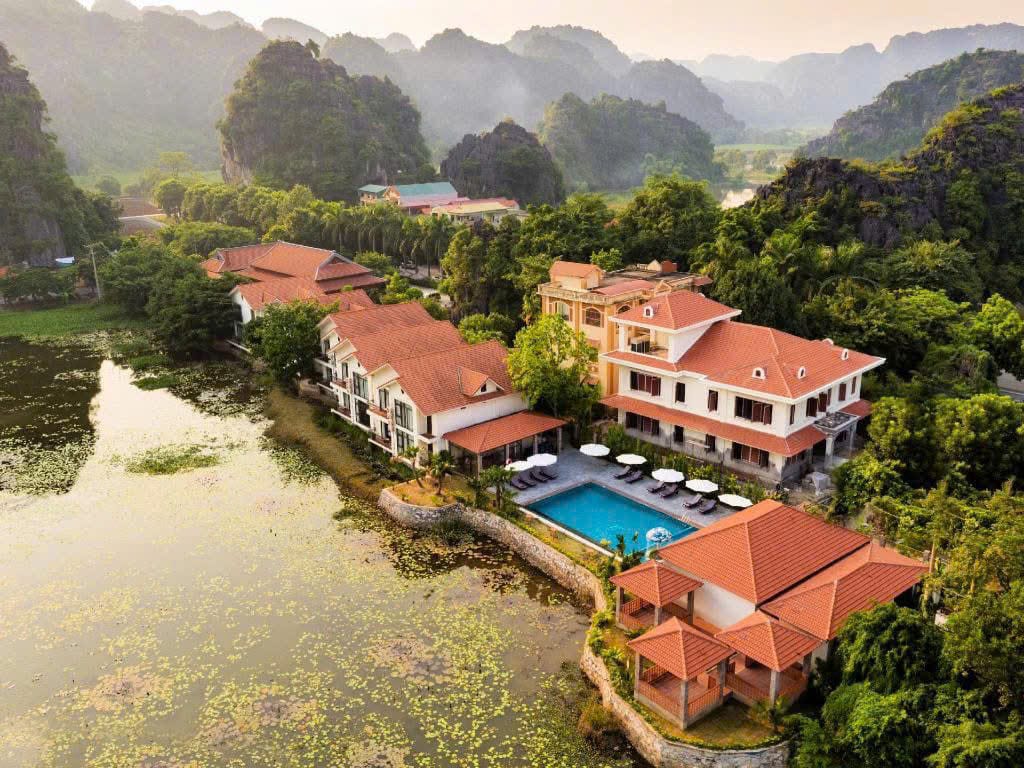 A stylish pool area set against striking limestone mountains at Tam Coc La Montagne, a luxury Trang An Resort.