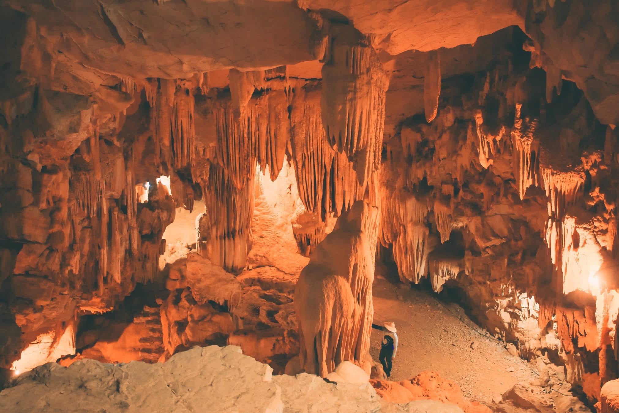 The dramatic stalactites and shimmering formations inside the large chambers of Vai Gioi Cave .