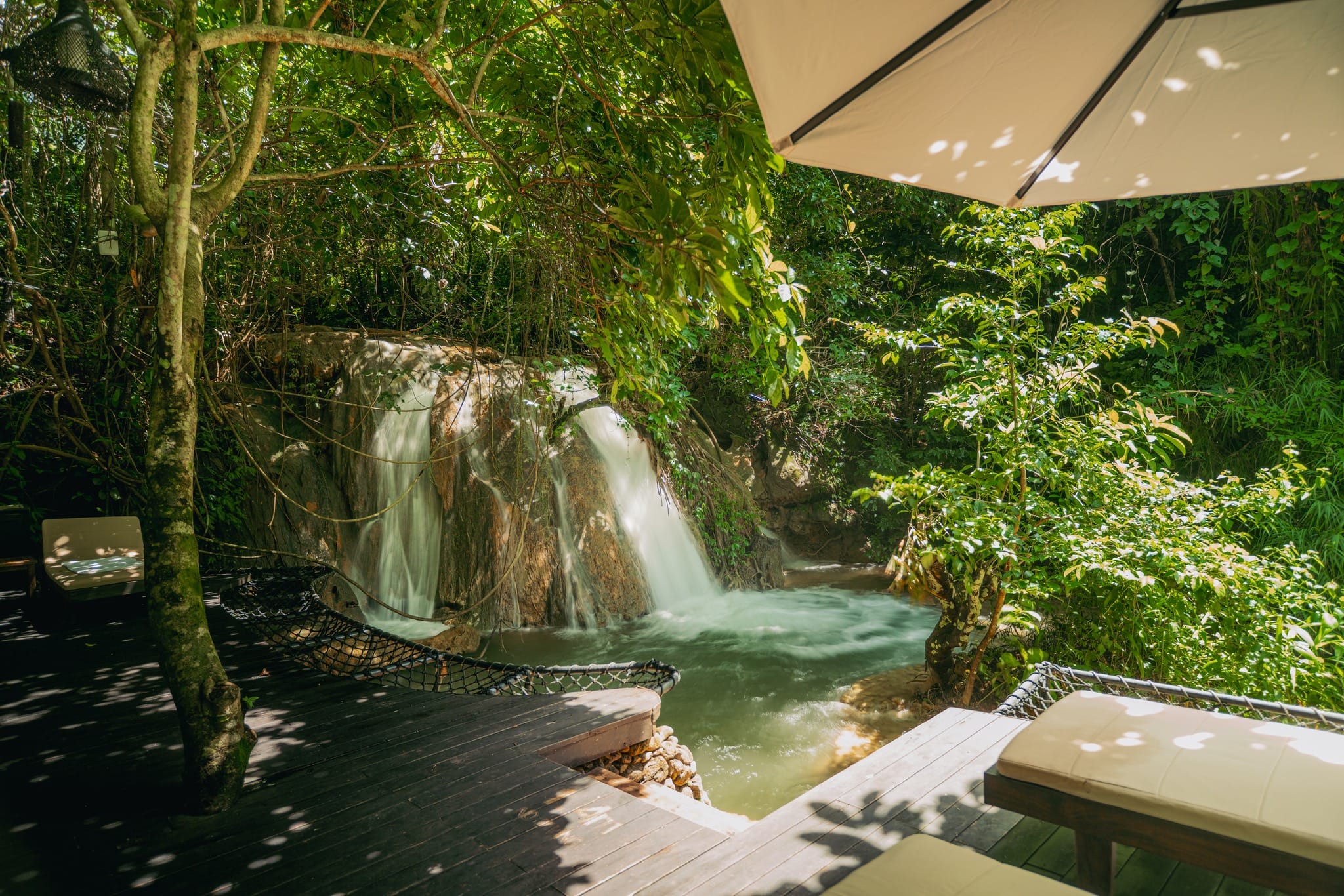 Practicing yoga by a private waterfall, an organic wellness experience at this mountain-based vietnam resort.