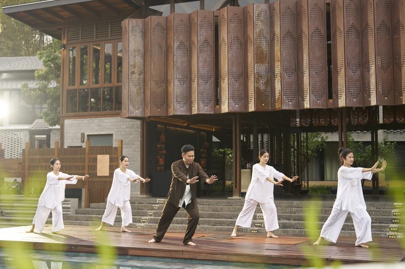 A solo traveler participating in a peaceful sound healing session guided by a certified wellness practitioner.