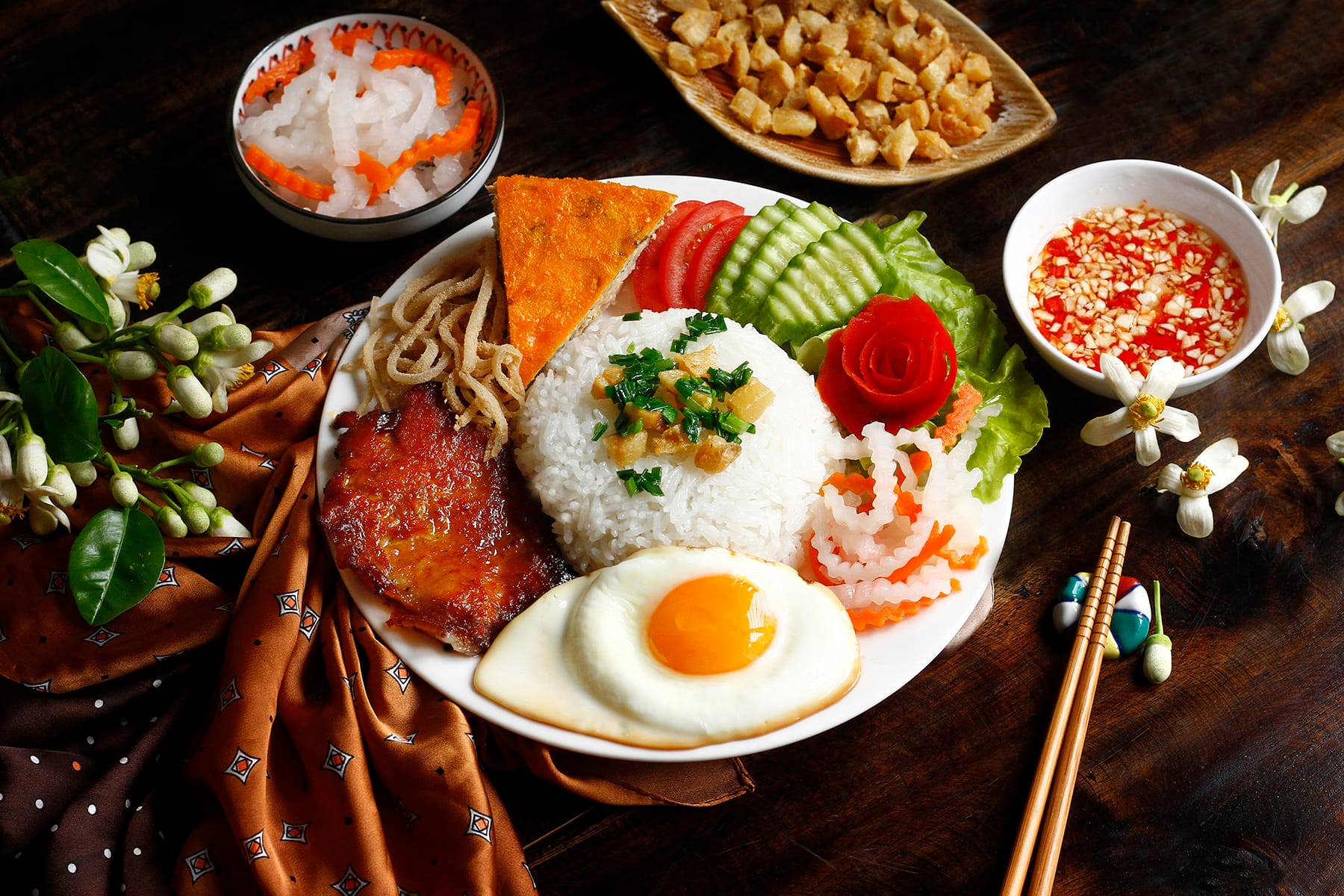 A beautifully plated of authentic com tam served with fresh veg and grilled pork 
