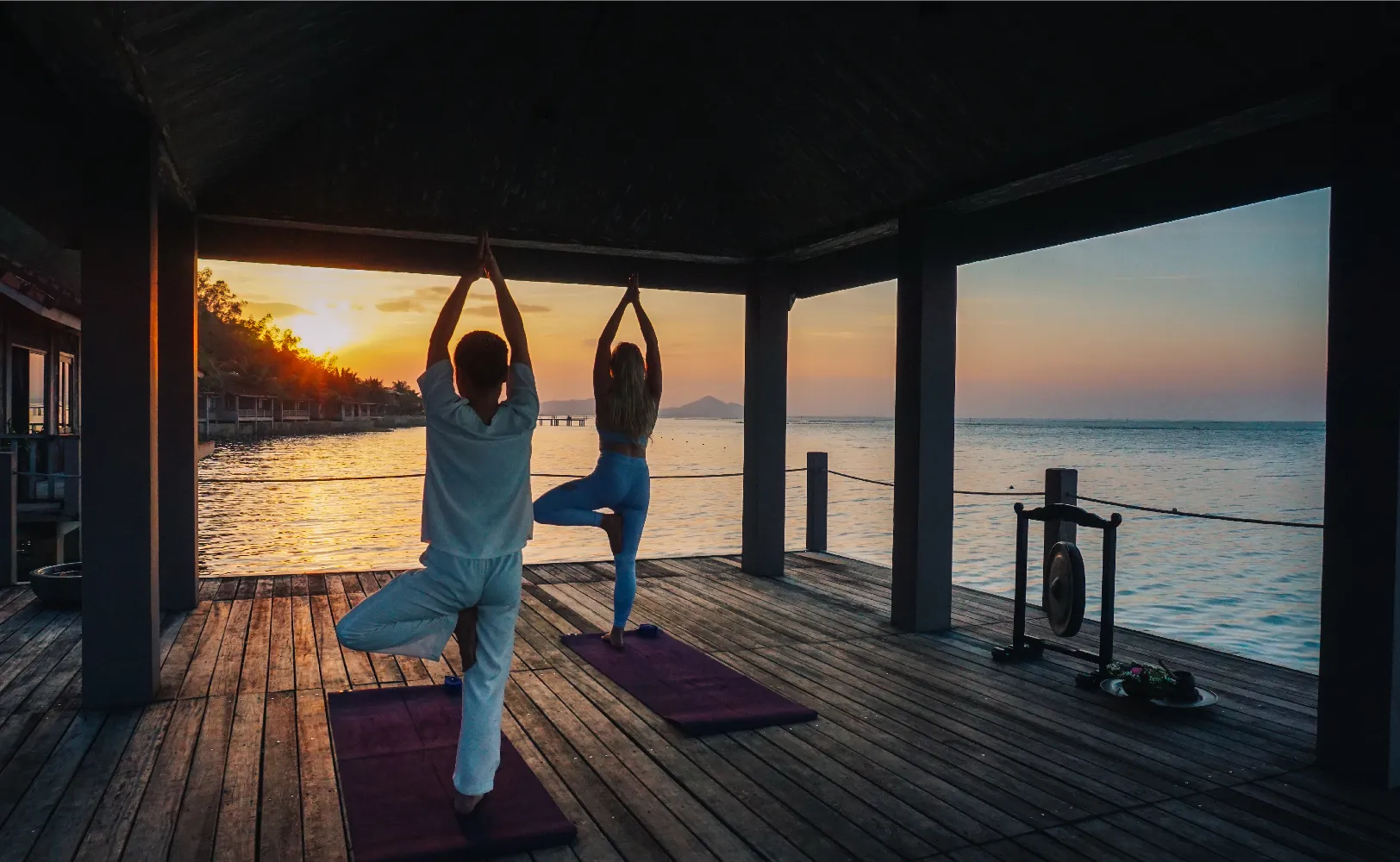 A serene shot of an open-air treatment pavilion overlooking clear ocean waters.