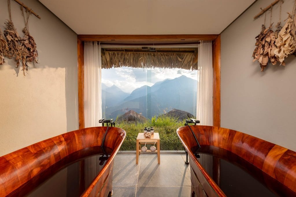  relaxing in a traditional wooden tub filled with steaming Red Dao herbal water.  