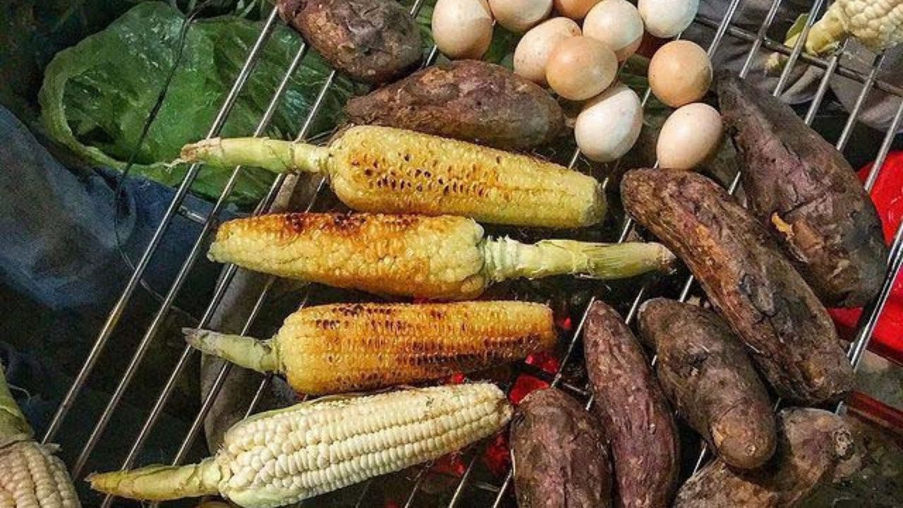 Vietnam Autumn Cuisine: From Green Rice to Warm Desserts Corn and sweet potatoes roast over a street-side charcoal grill.